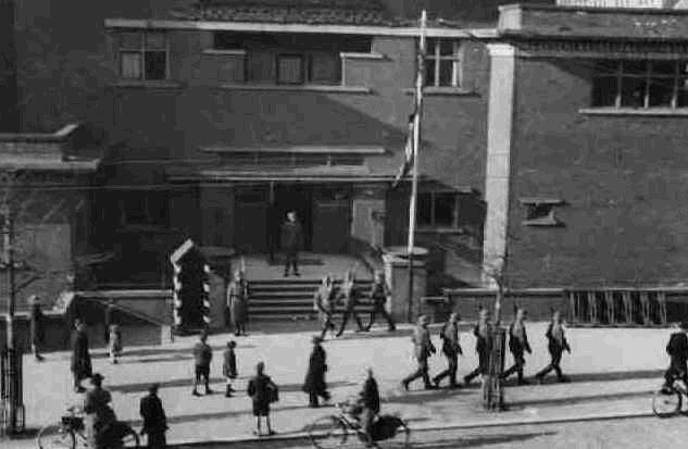 Het aflossen van de wacht door Duitse militairen voor het door militairen bezette Sint-Franciscuscollege aan de Beukelsdijk. (1944)